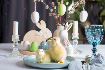 Easter table setting, yellow chickens, painted eggs. Easter willow in a vase