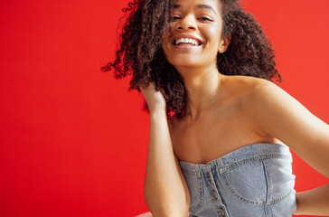 Charming mixed race girl smiling and posing in denim top and tulle tutu skirt