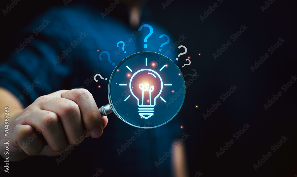 Aufkleber businessman holding magnifier glass with virtual glowing lightbulb with question mark for focus on p