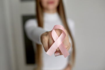 A woman in a white sweater with a pink fly in support of breast cancer patients.