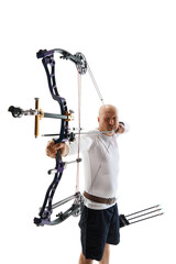 Man in his 40s, archery athlete with bow and arrow aiming at archery target isolated over white...