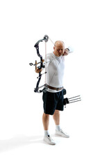 Man, professional archer training, aiming archery bow into target isolated over white studio background. Concept of professional sport and hobby, competition, action, game