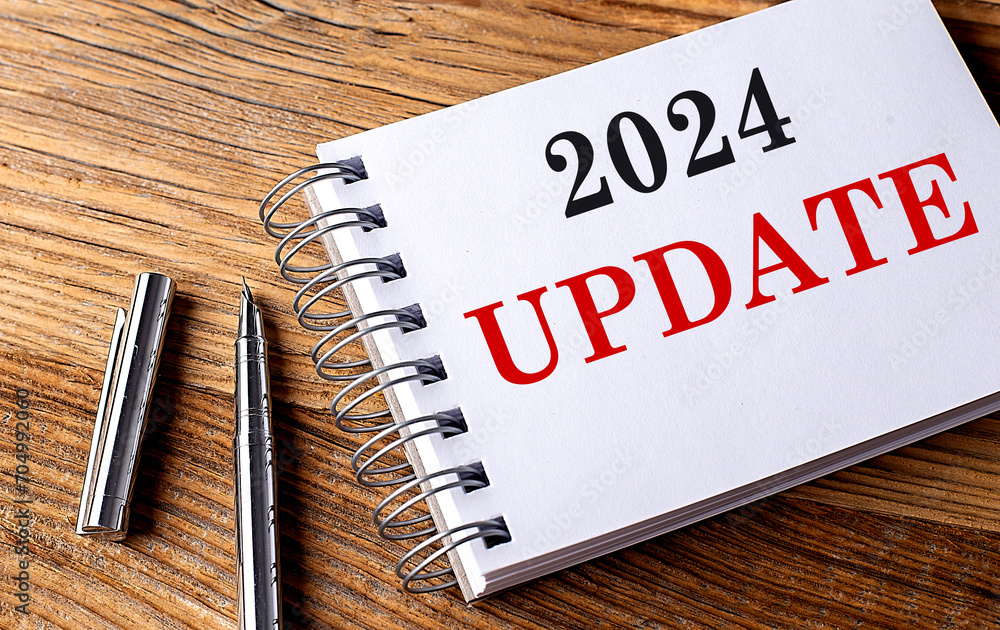 Poster 2024 update text on notebook with pen on wooden background