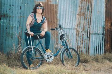 Mujer joven y hermosa posando junto a su bicicleta vintage
