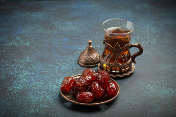 Breaking fasting with dried dates during Ramadan Kareem, Iftar meal with dates and Arab tea in...