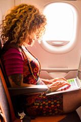 Woman travel on airplane and work with computer laptop and wireless internet connection on beard -...
