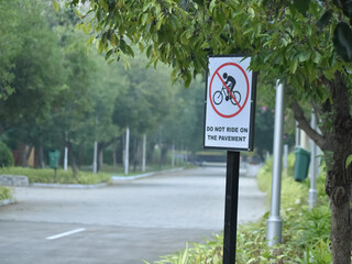 A closeup sign board banning movement of cycle or vehicle on pavement.