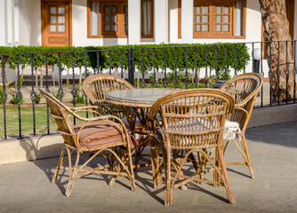 wooden rotan chairs and a round table on the background of the resort house in Egypt Dahab South Sinai