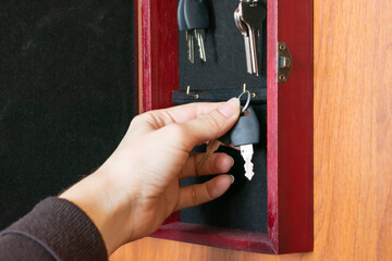 Bunch of keys in safe box. Young female hands hanging key, concept of secure safety of houses, home.