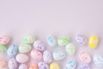 Background with copy space pattern with multi colored easter eggs in yellow, pink, green, blue colors.