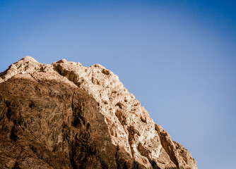 high rocky mountain against a clear blue sky