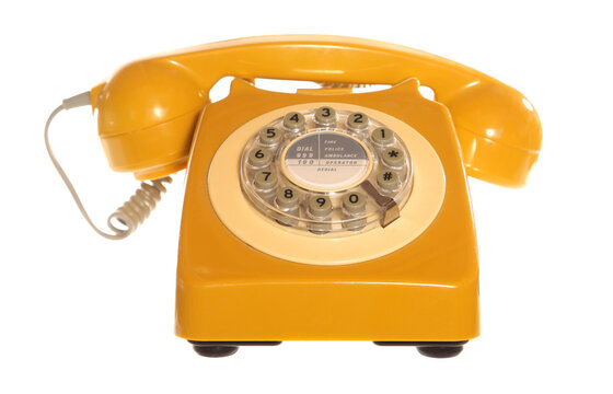 Retro corded rotary yellow telephone isolated on a white background
