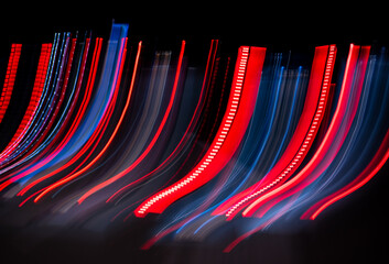 Blurred moving red, blue and white lights on a german Autobahn seen through the windshield while...