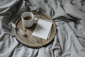 White cup of coffee wooden tray. Breakfast in bed with bunny tail dry grass. Neutral blank greeting...