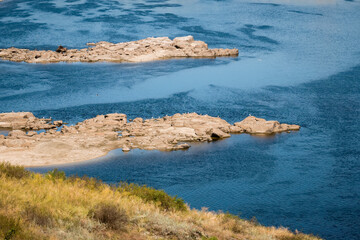 Fototapeta na wymiar Rocks in the water resembling crocodiles