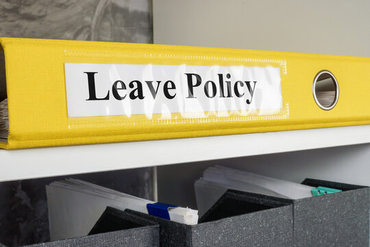 The folder Leave policy lies on the office shelf.