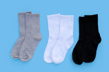 Grey, white and black socks on blue background.
