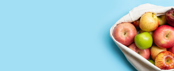 Variety of fresh apples on blue background.