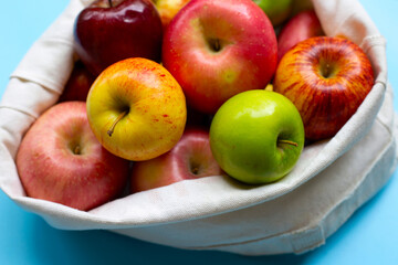 Variety of fresh apples on blue background.