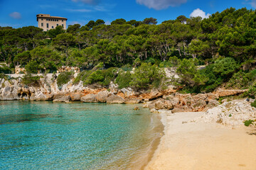Beautiful sandy beach Cala Gat with clear blue waters and natural surroundings