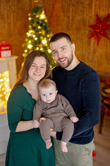 Cute newborn child, baby boy, with mom and dad on Christmas