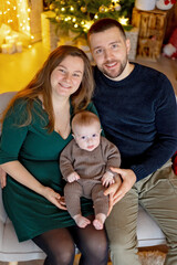 Cute newborn child, baby boy, with mom and dad on Christmas