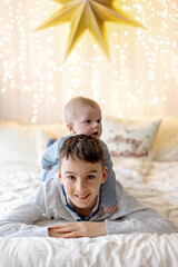 Happy family, newborn baby and older brothers, mom at home on Christmas