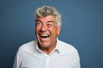 Handsome middle age man shouting over isolated blue wall background.