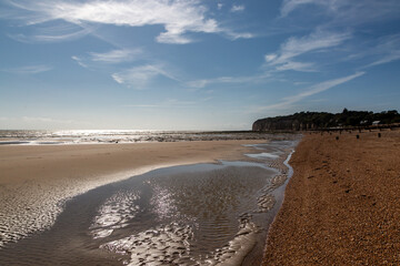 Looking along the beach at Pett Level on the Sussex coast, with the sun shimmering on the water