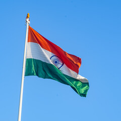 India flag flying high at Connaught Place with pride in blue sky, India flag fluttering, Indian Flag on Independence Day and Republic Day of India, tilt up shot, Waving Indian flag, Har Ghar Tiranga