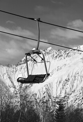 Ski-lift on ski resort and snowy mountains at sunny day - 705025680