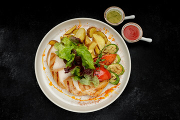 Fried chicken breast with grilled vegetables, mixed greens and potatoes
