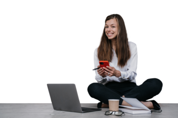 Excited young woman sitting on floor with laptop making video call smiling wide holding phone against transparent background. business woman having remote meet via internet.