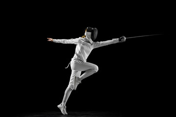 Confidence and strength. Female athlete in fencing gear showcasing her impeccable form, sword...