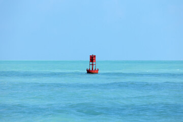 An isolated red ocean buoy. Channel marker. Nautical signage.