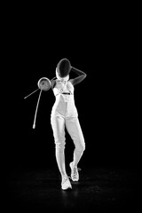 Full length portrait of mastery of sportswoman as she poses with crossed swords, performing...