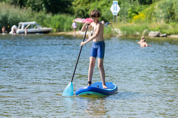 Teenager and SUP board. Active recreation on the Senftenberg lake. Federal land of Brandenburg. Germany.