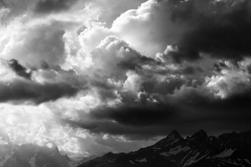 Black and white high mountains and storm clouds - 705041282