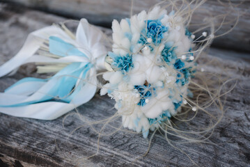 Stylish bouquet of white and blue flowers on a wooden background. Luxury marriage and wedding accessory concept. Winter style. Engagement. Side view.