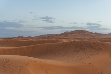 minimalist look of big sand dunes in the desert morocco with orange color view at sunset time