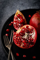 Pomegranate. Parts of a whole Pomegranate on a dark background.