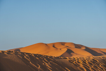 close up minimalist look of big sand dunes in the desert morocco with orange color view 