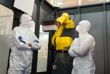 Technician engineers check robot arms and repair automatic robotic machines at the industrial...