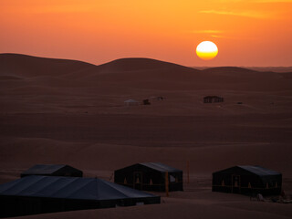 Fototapeta premium Sun setting over a desert camp in Zagora province, Morocco