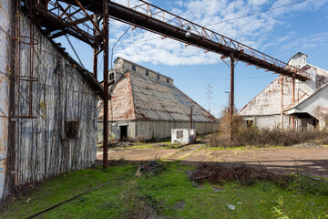 Open area between buildings of abandoned wood factory on clear day - 705059686