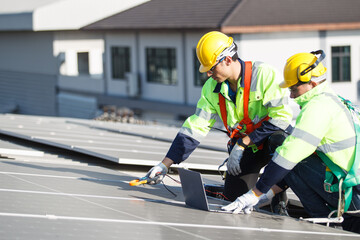 Professional electric engineers survey and inspect solar panels installation on the factory metal sheet roof top.