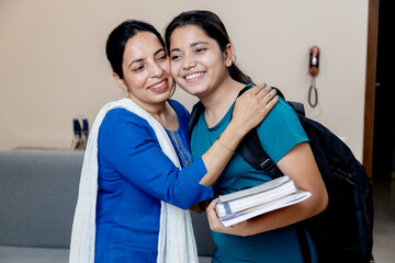 Indian mother Wishing her daughter best wishes for exam by kissing her on forehead and hug her