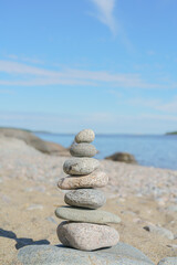Fototapeta na wymiar Stacked Rocks balancing, stacking with precision. Stone tower on the shore. Copy space