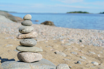 Fototapeta na wymiar Stacked Rocks balancing, stacking with precision. Stone tower on the shore. Copy space