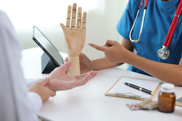 Man with arm pain, wrist pain is seeing a doctor for diagnosis in an examination room at a hospital.